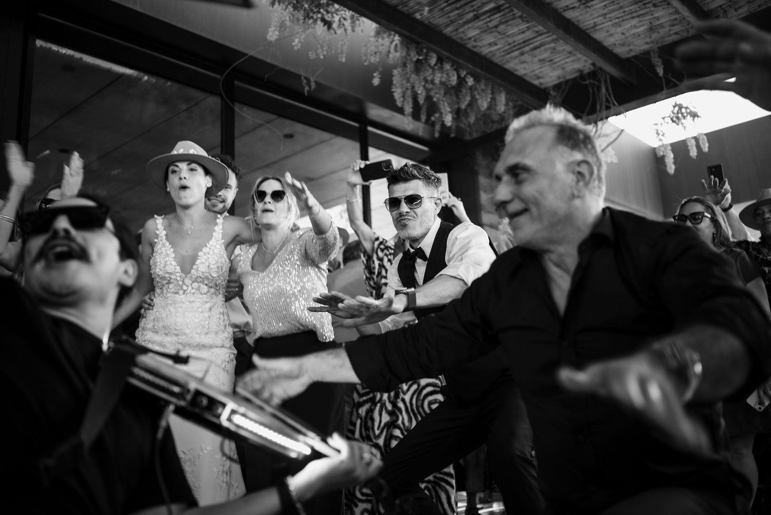 A black and white photograph showing patrons sitting at a bar counter in what appears to be a vintage establishment.