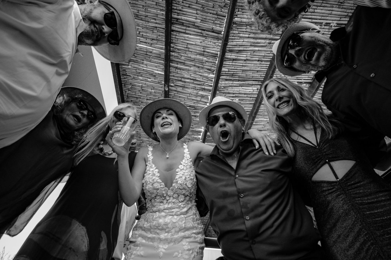 A collection of black and white wedding photos showing candid moments of celebration and joy at a reception.