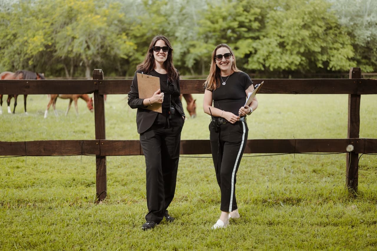 People walk on a grassy path at a park while enjoying outdoor activities with their pets and companions.