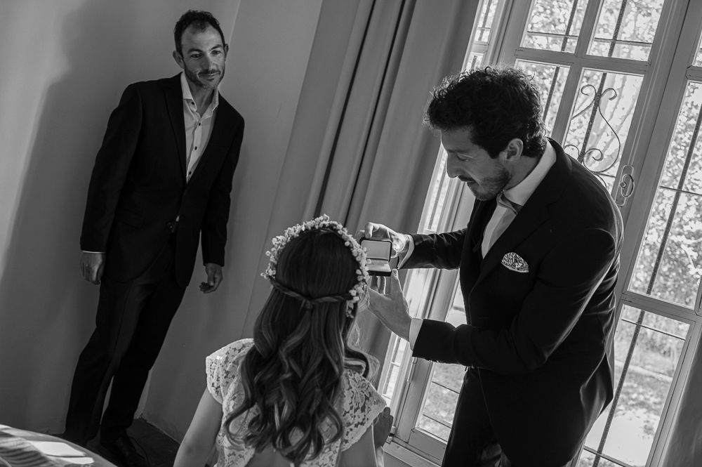 A series of black and white photos showing people in formal attire standing in a room with windows. wedding in mendoza