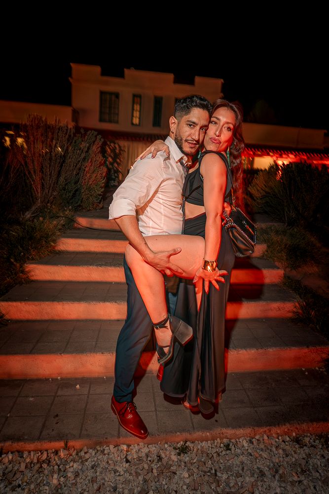 A couple poses intimately in an outdoor setting at night with warm lighting and red tones. wedding in mendoza