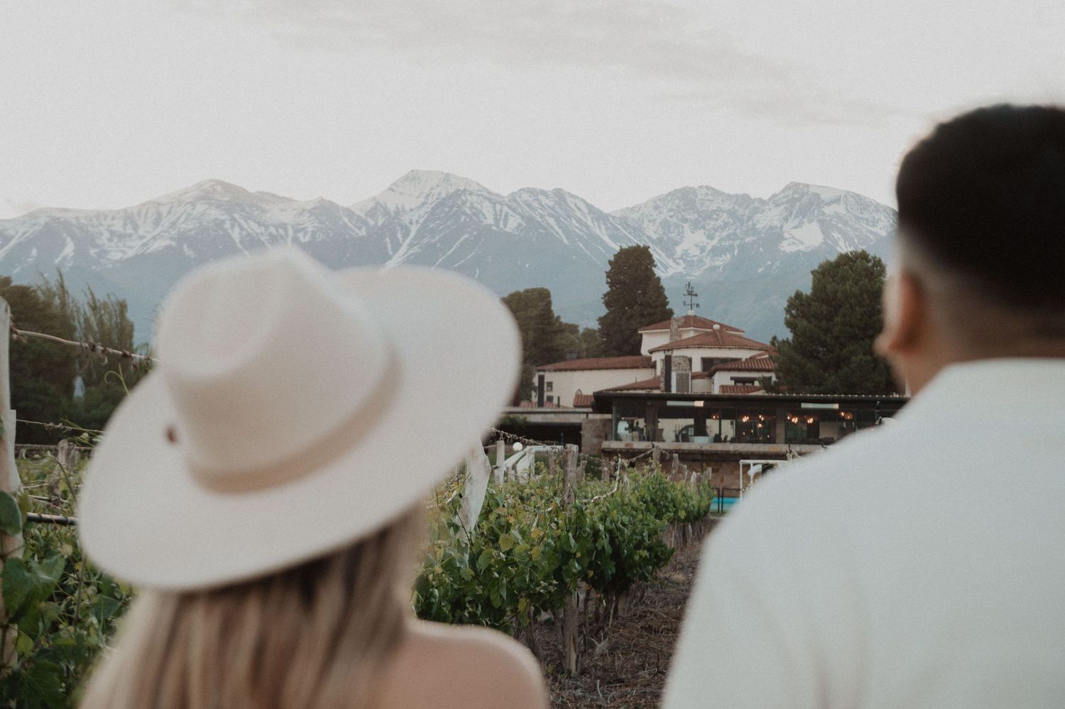 View of mountain lodge with couple overlooking scenic mountain range.