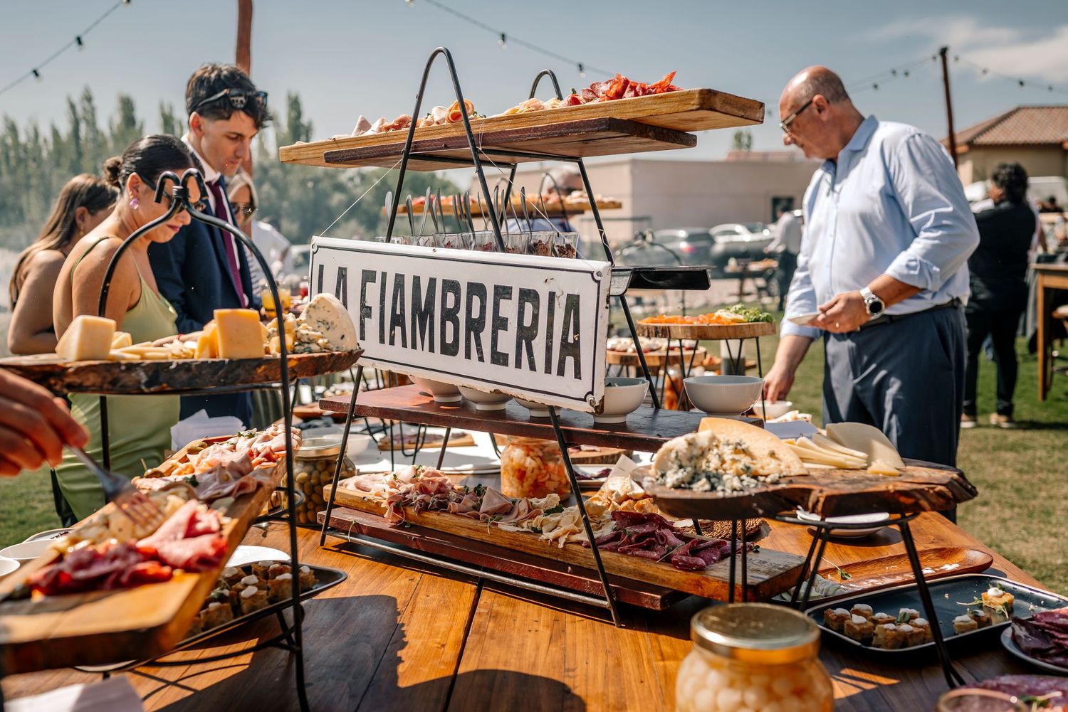 Rustic outdoor food market display with wooden tables showcasing fresh breads and baked goods under canopy tents.
