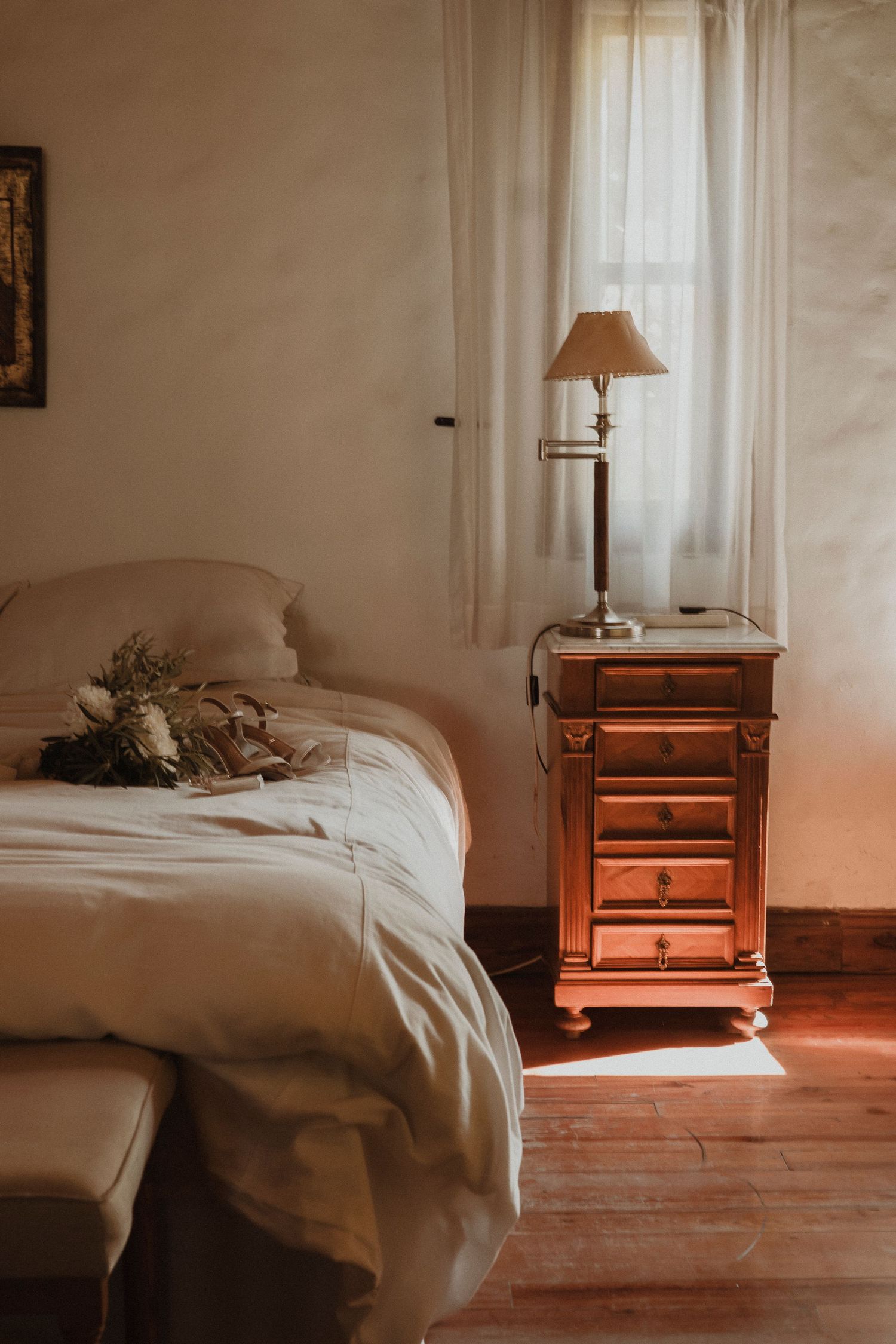 A series of minimalist bedroom photos showing white bedding and wooden nightstands in warm lighting.