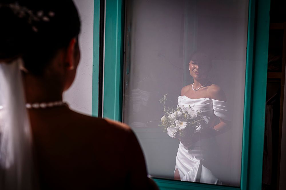 Intimate wedding photography session with soft lighting and teal-colored window frames in background. wedding in mendoza
