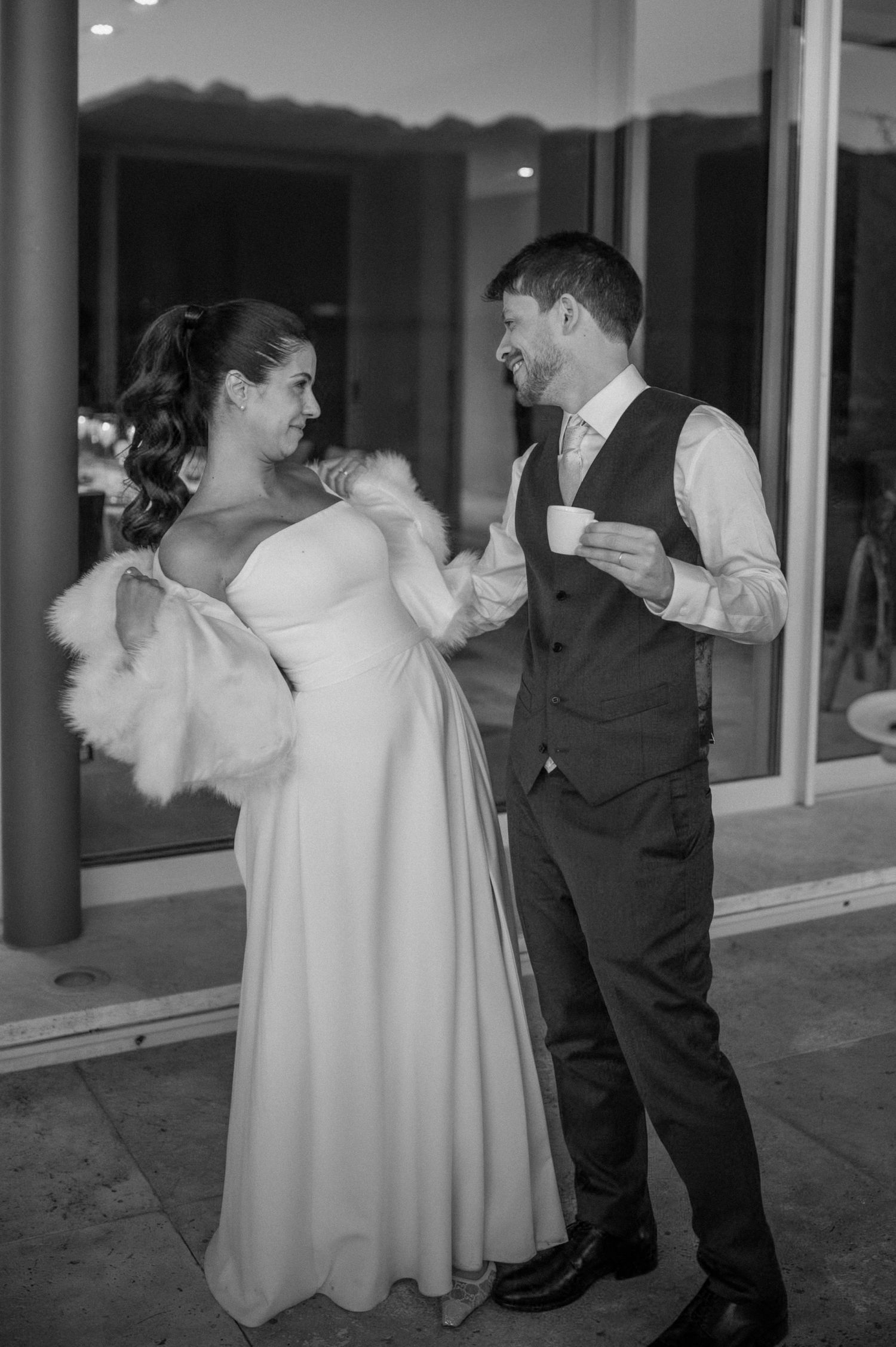 Black and white photo of a bride in white gown with fur wrap and groom in suit sharing a quiet moment. fotógrafos de boda en Mendoza
