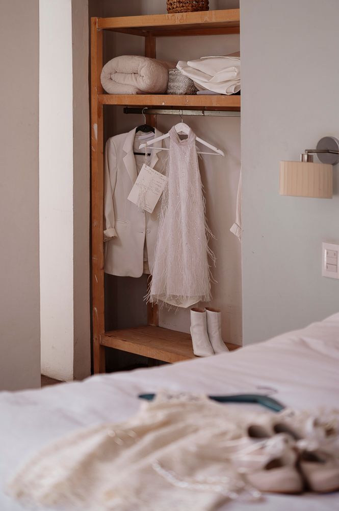 Clean white linens and clothing neatly arranged on wooden shelves in a minimalist closet interior.
