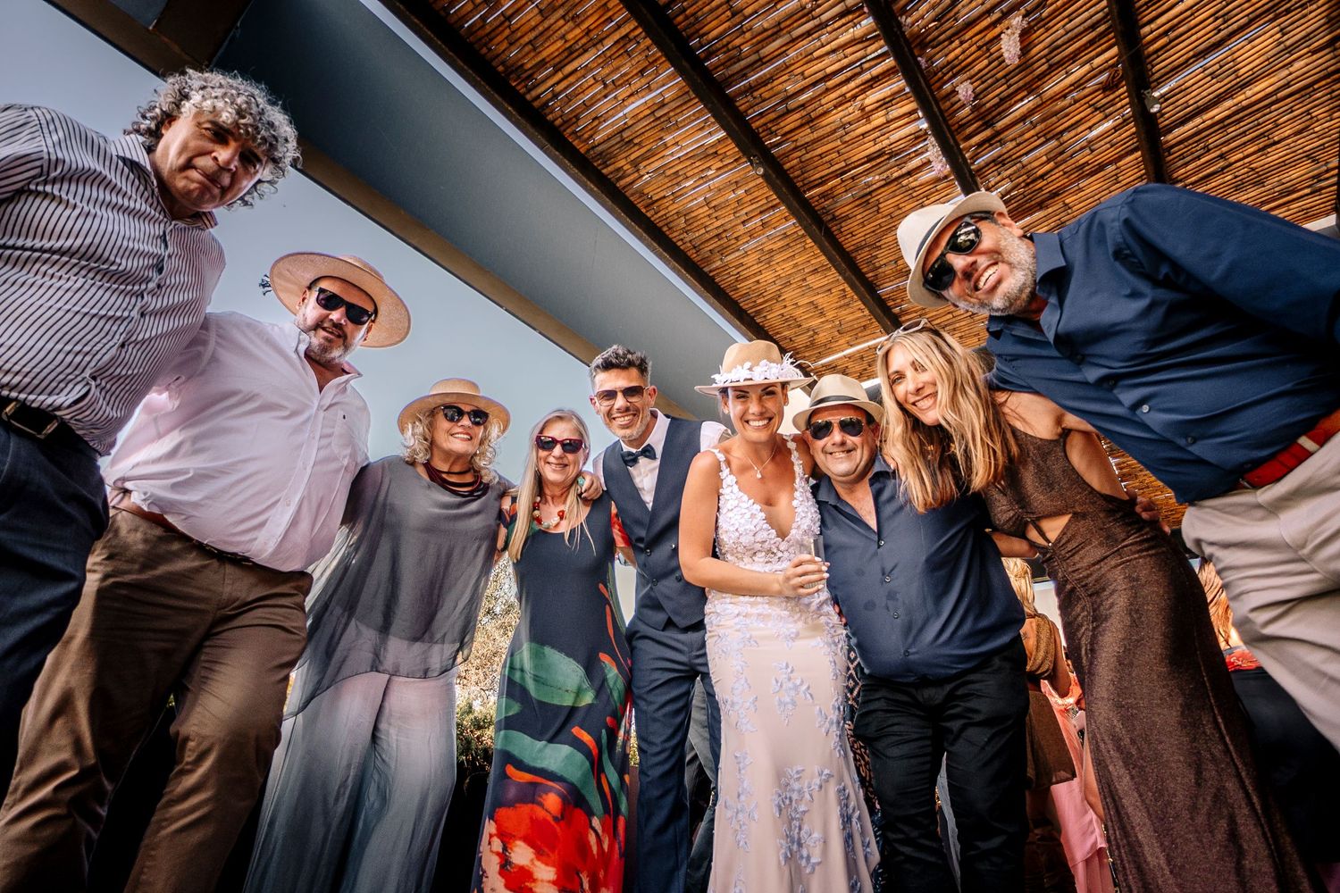 Wedding guests dance and celebrate together on a rustic wooden floor during a reception party.