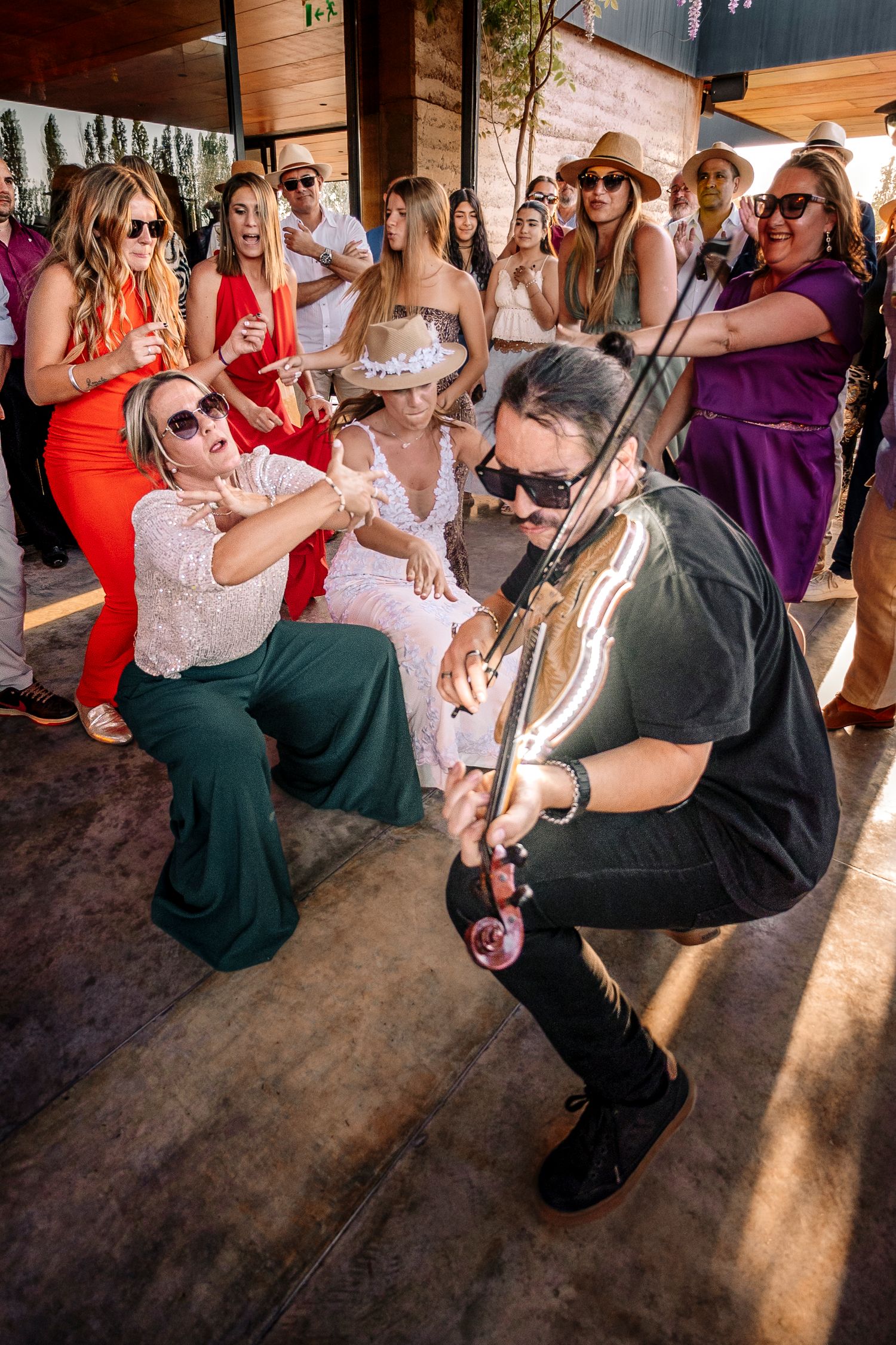 Wedding guests gather around as a couple participates in a traditional garter toss at a reception celebration.