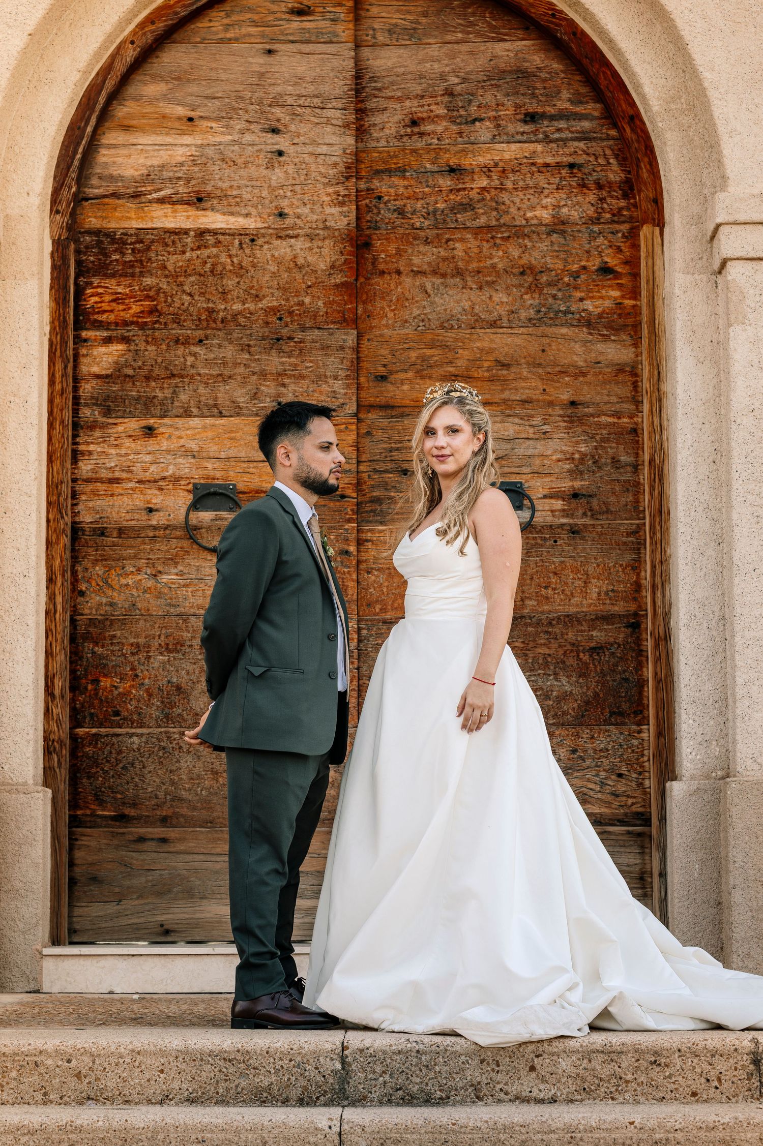 Bride and groom share intimate moments in rustic stone archway during wedding photoshoot. fotografos de boda en mendoza