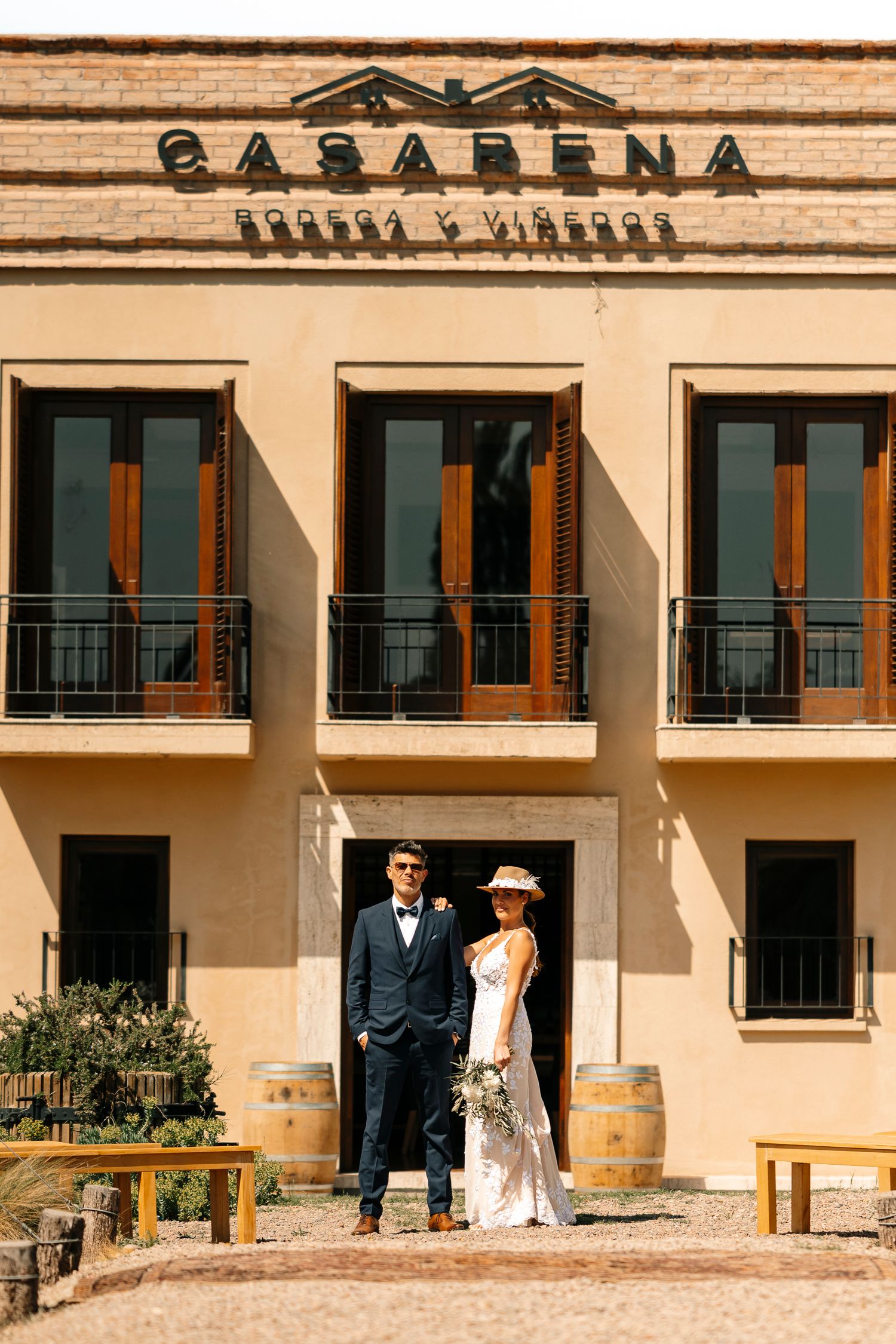 A panoramic view of a Mediterranean-style building exterior with multiple arched doorways and windows in warm beige tones.