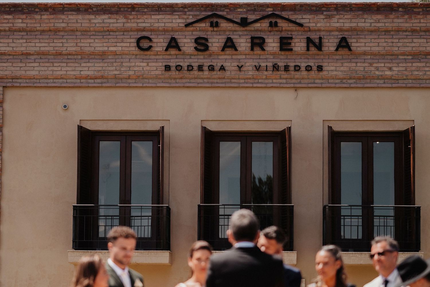 People gather outside the brick facade of Casarena winery building in Mendoza, Argentina.