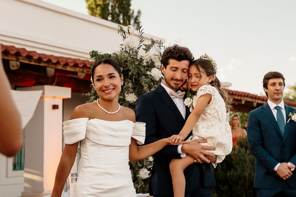 A joyful wedding celebration outdoors at a Spanish-style venue with white architectural details and greenery. wedding in mendoza