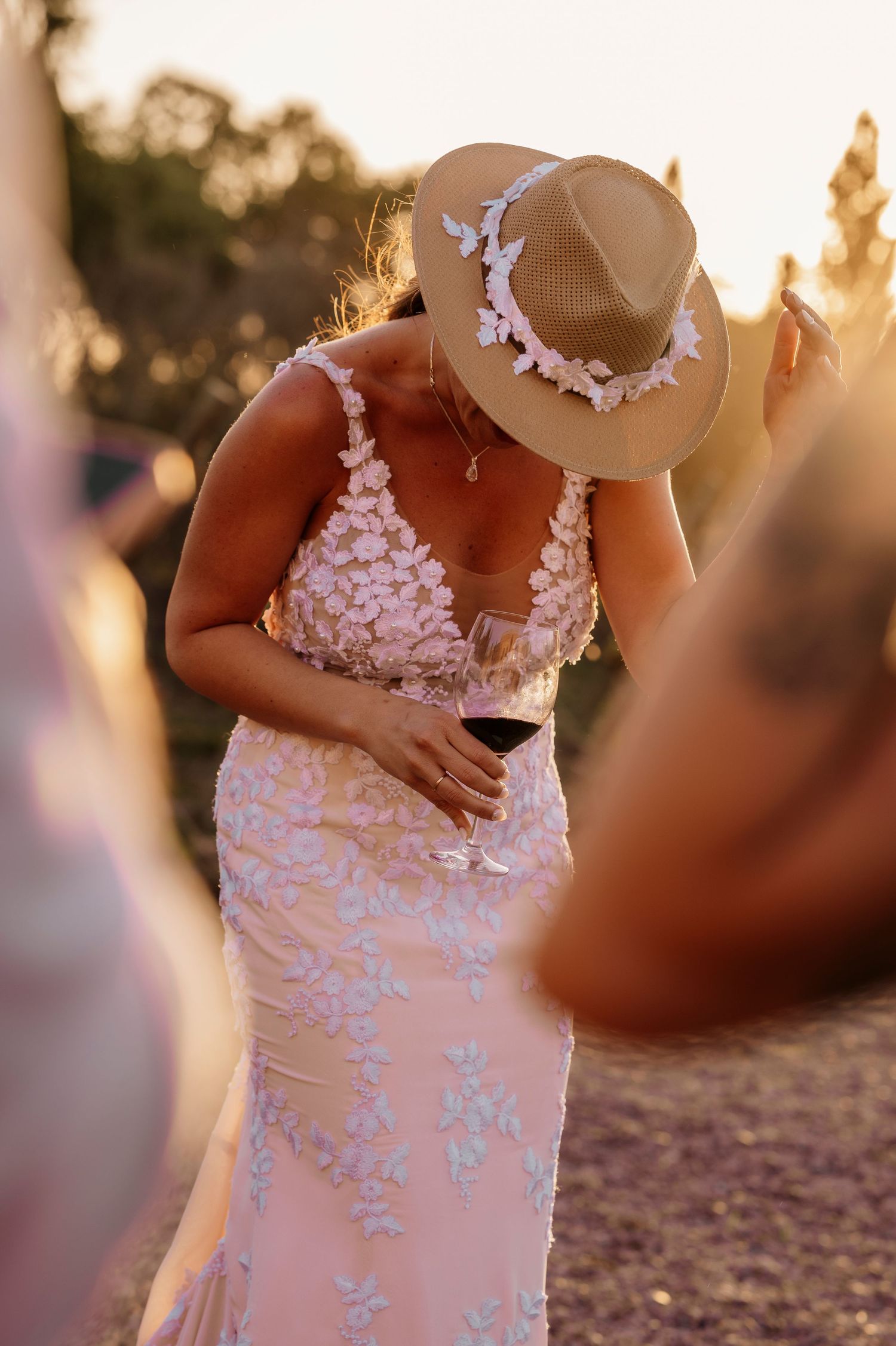 A close-up view of delicate white lace details on a wedding dress bodice at sunset.