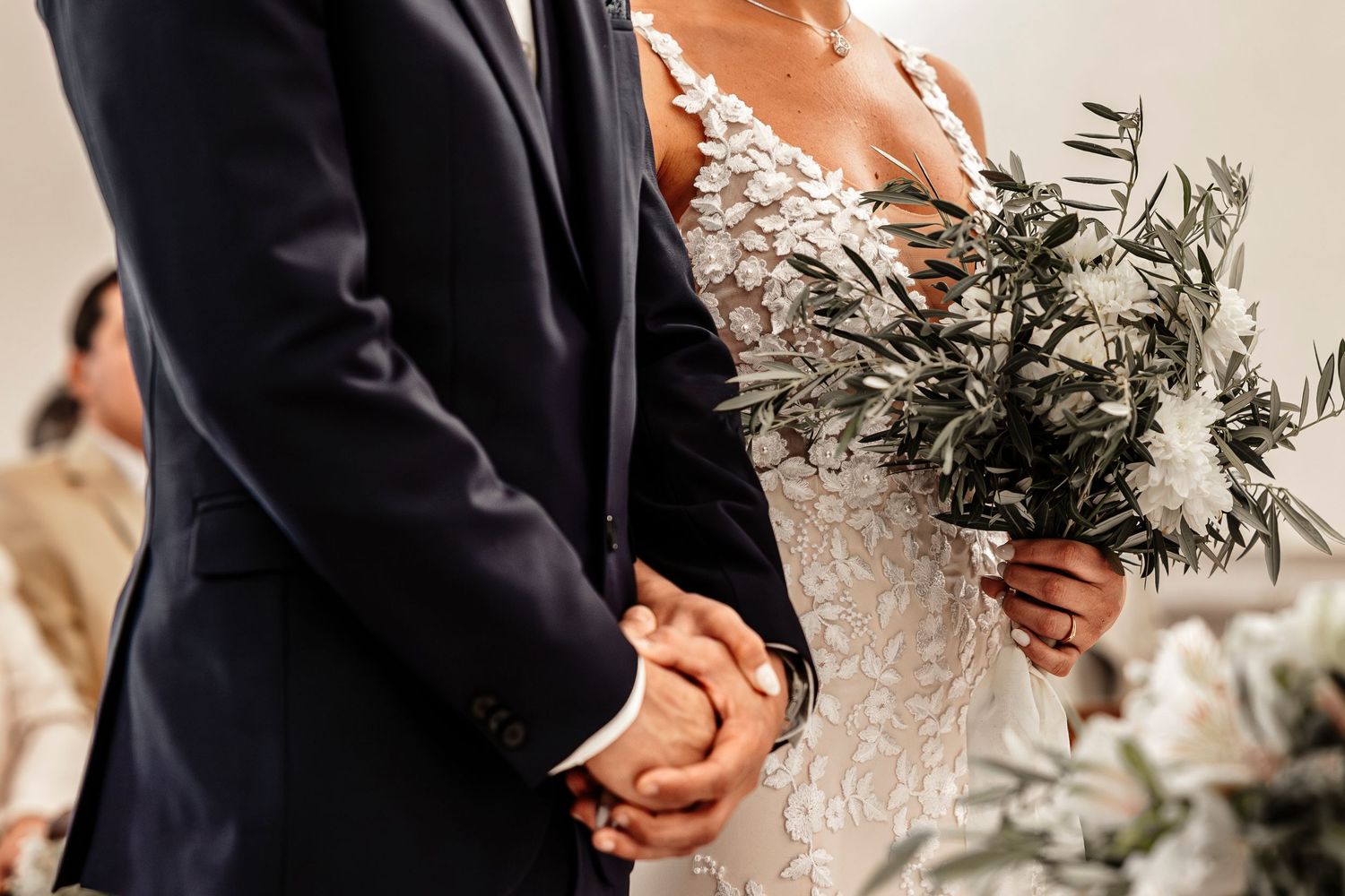 Wedding ceremony in progress showing formal attire and floral arrangements at the altar.