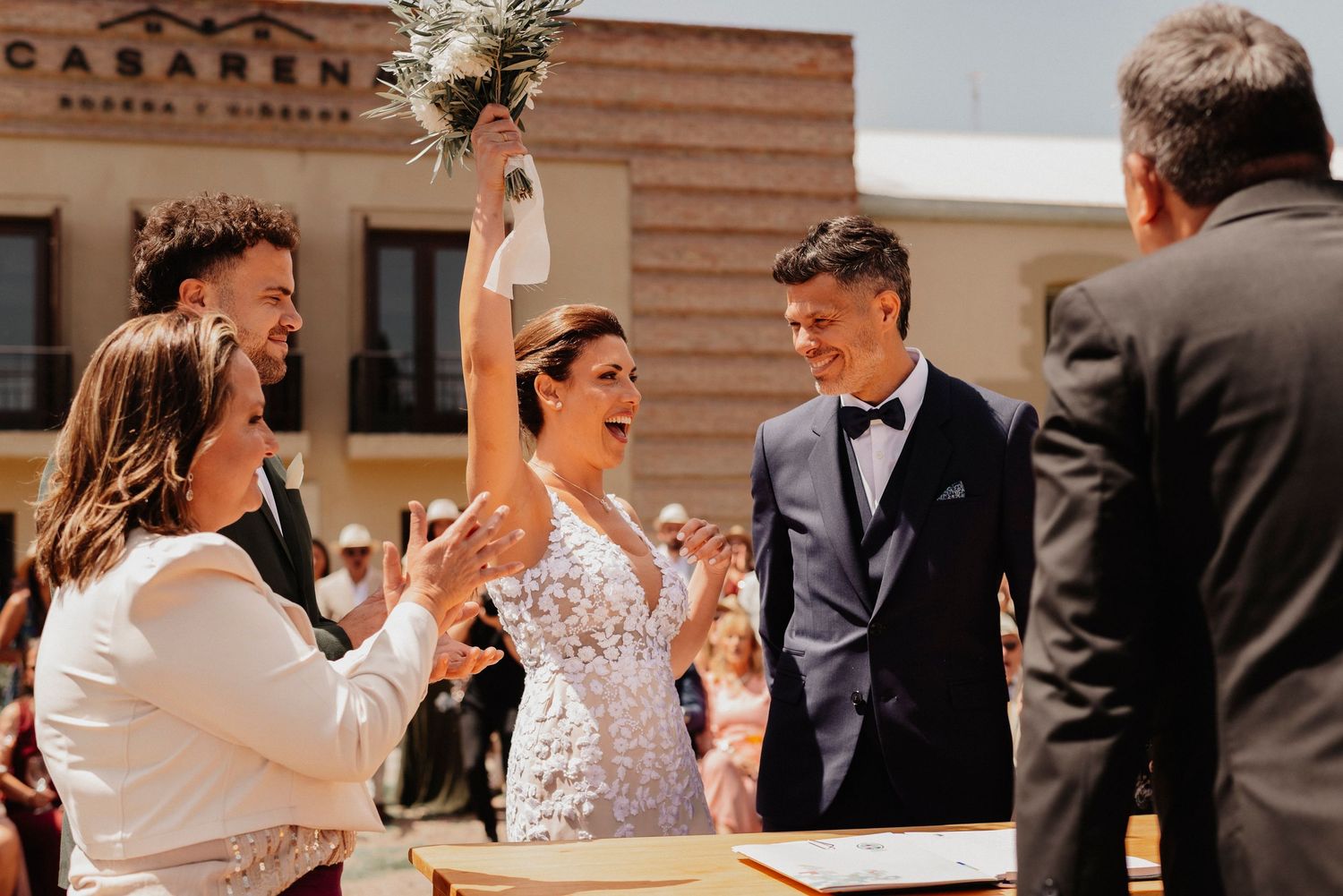 Wedding guests dance and celebrate together on a dance floor at an indoor reception venue.