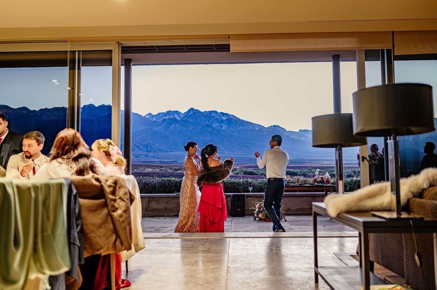 Couple shares first dance at elegant indoor wedding venue with stunning mountain backdrop at dusk. fotógrafos de boda en Mendoza