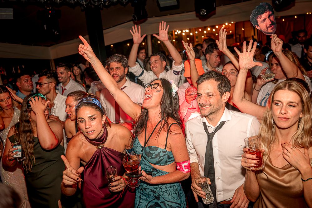 Crowded dance floor at a nightclub with people dancing and raising their hands in celebration. wedding in mendoza