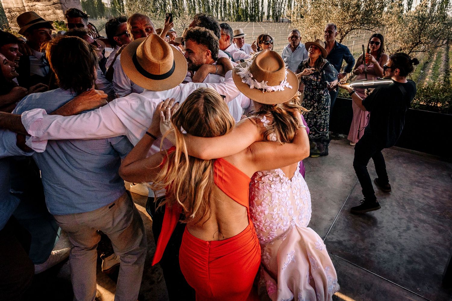 Couples dancing together at a social gathering with warm lighting and a rustic atmosphere.