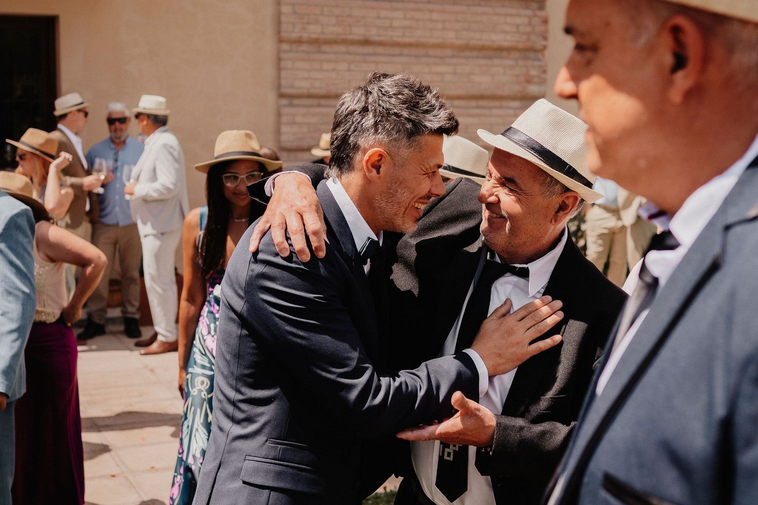 A series of candid black and white photos showing emotional moments between people at a wedding celebration.