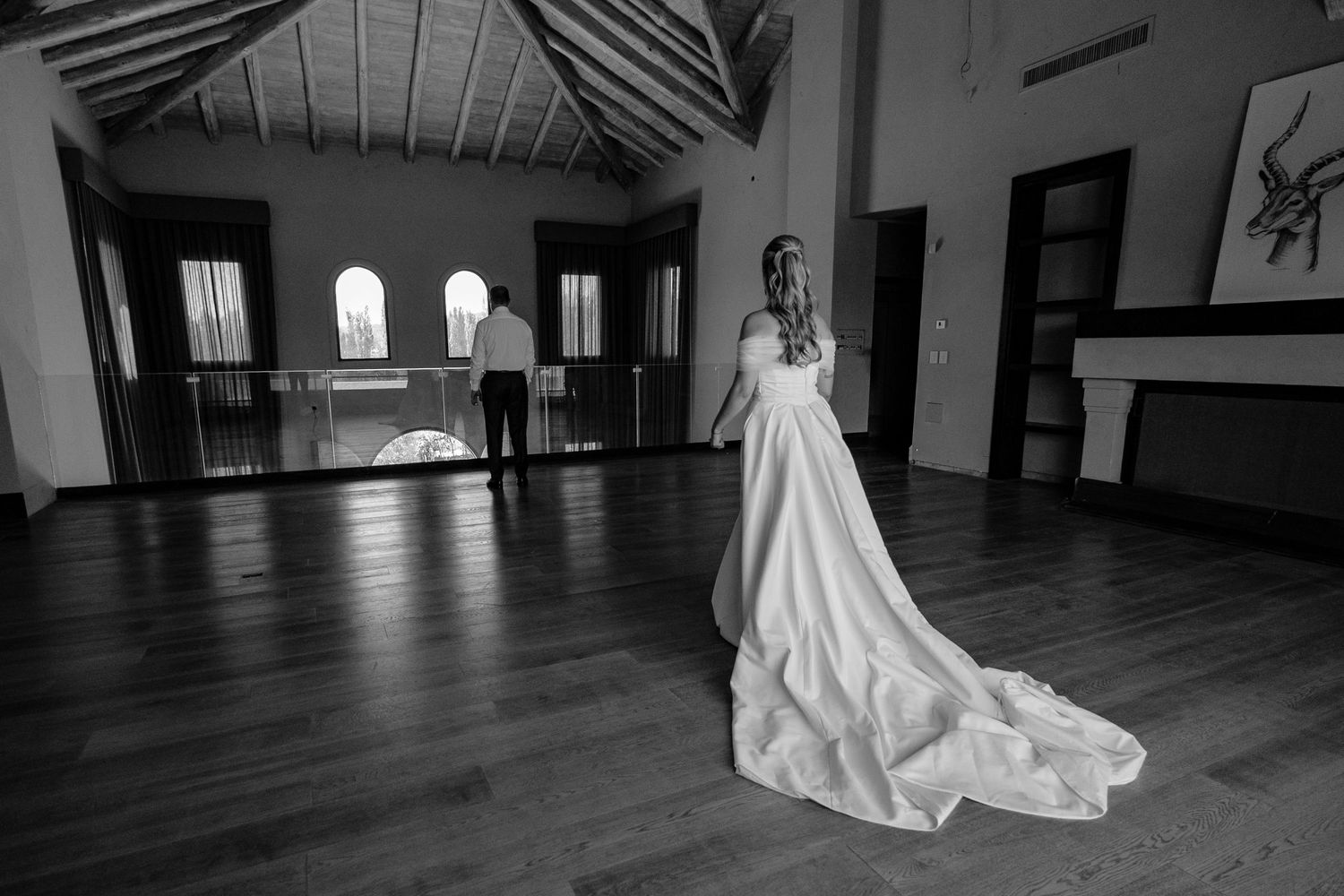 A dramatic black and white photo series shows a person in a flowing white dress moving through an empty wooden room.
