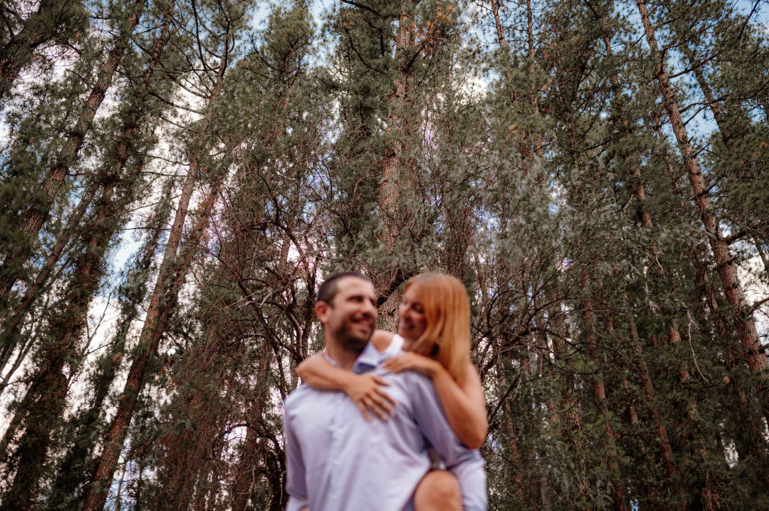 A couple shares intimate moments in a forest setting during an outdoor photo session. pre boda in mendoza