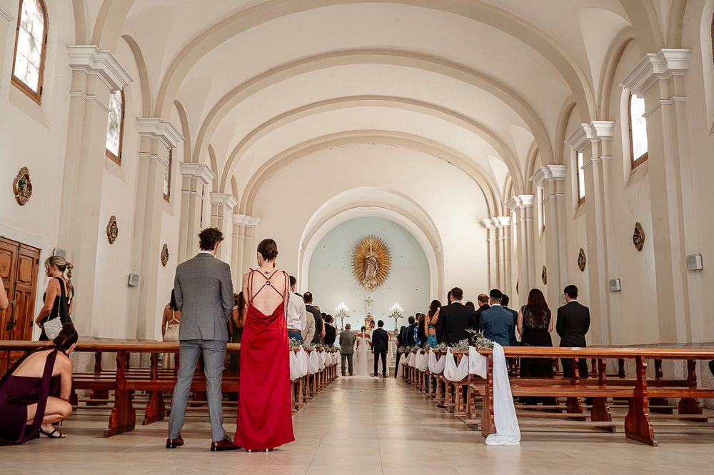 A series of connected images showing the interior of a white cathedral hallway with arched ceilings and religious statues. wedding in mendoz