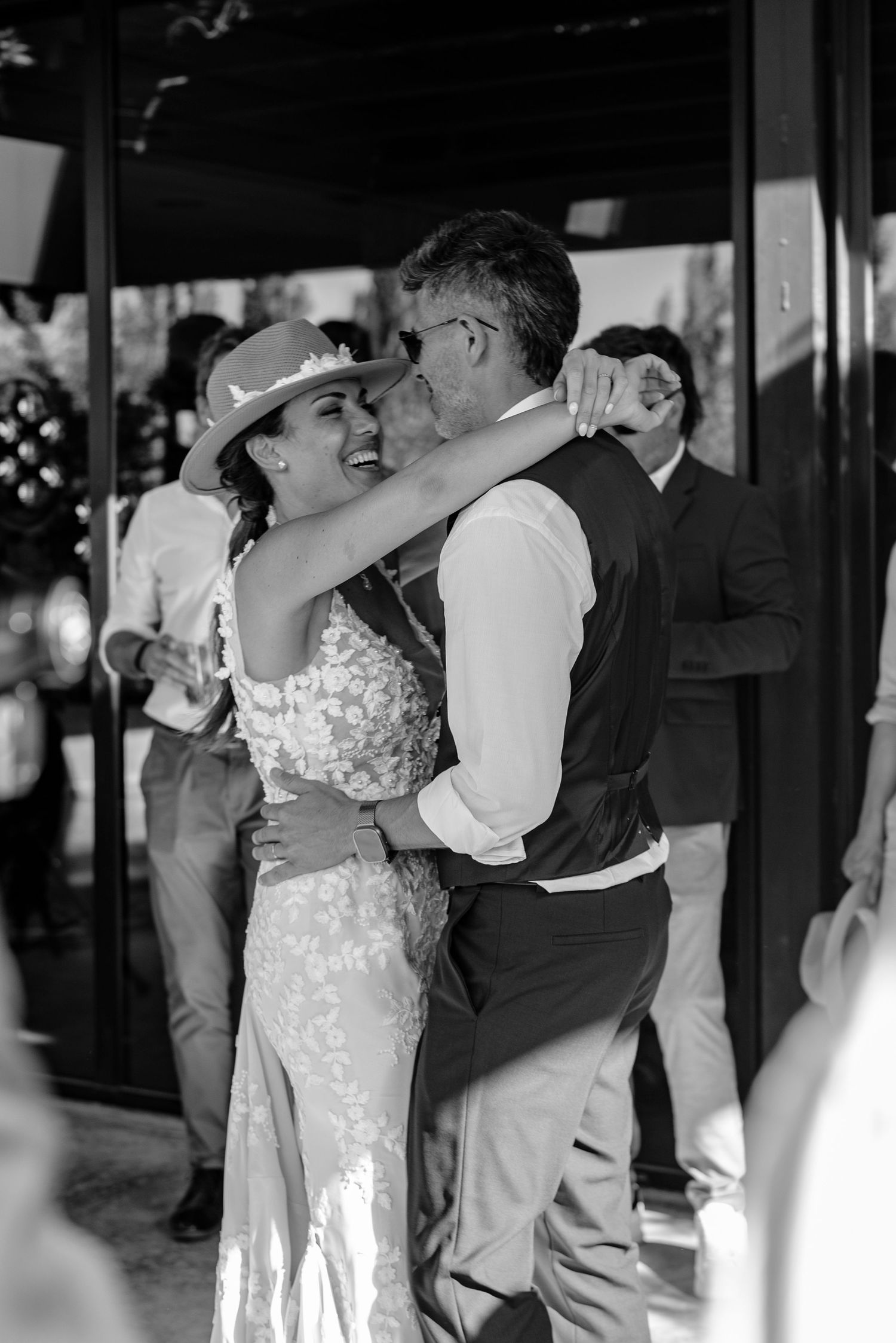 A couple shares their first dance at a wedding reception, with the bride wearing a white lace gown.