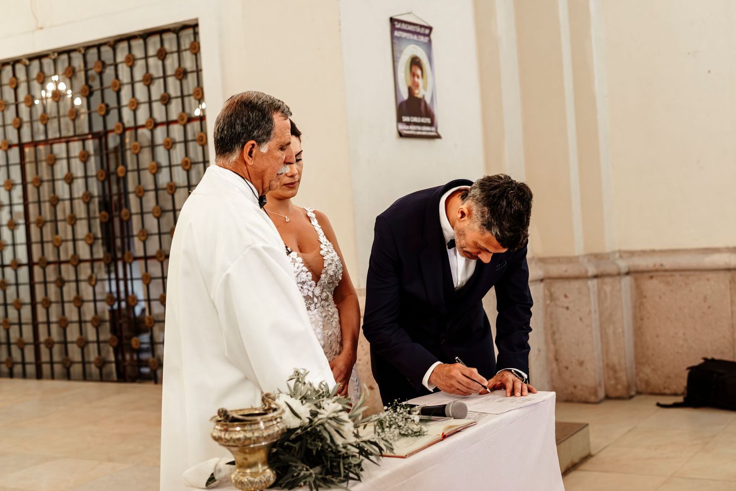 Two people stand at a table during what appears to be a formal signing ceremony or document registration event.
