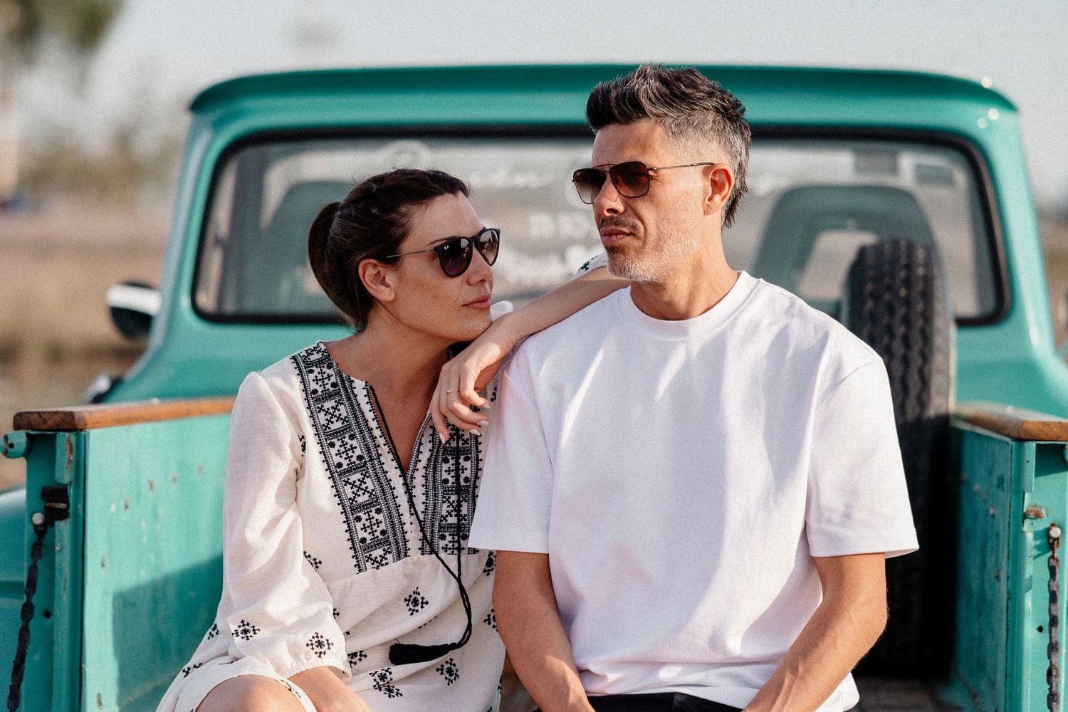 Couple sitting in a vintage turquoise truck sharing romantic moments in multiple candid shots.