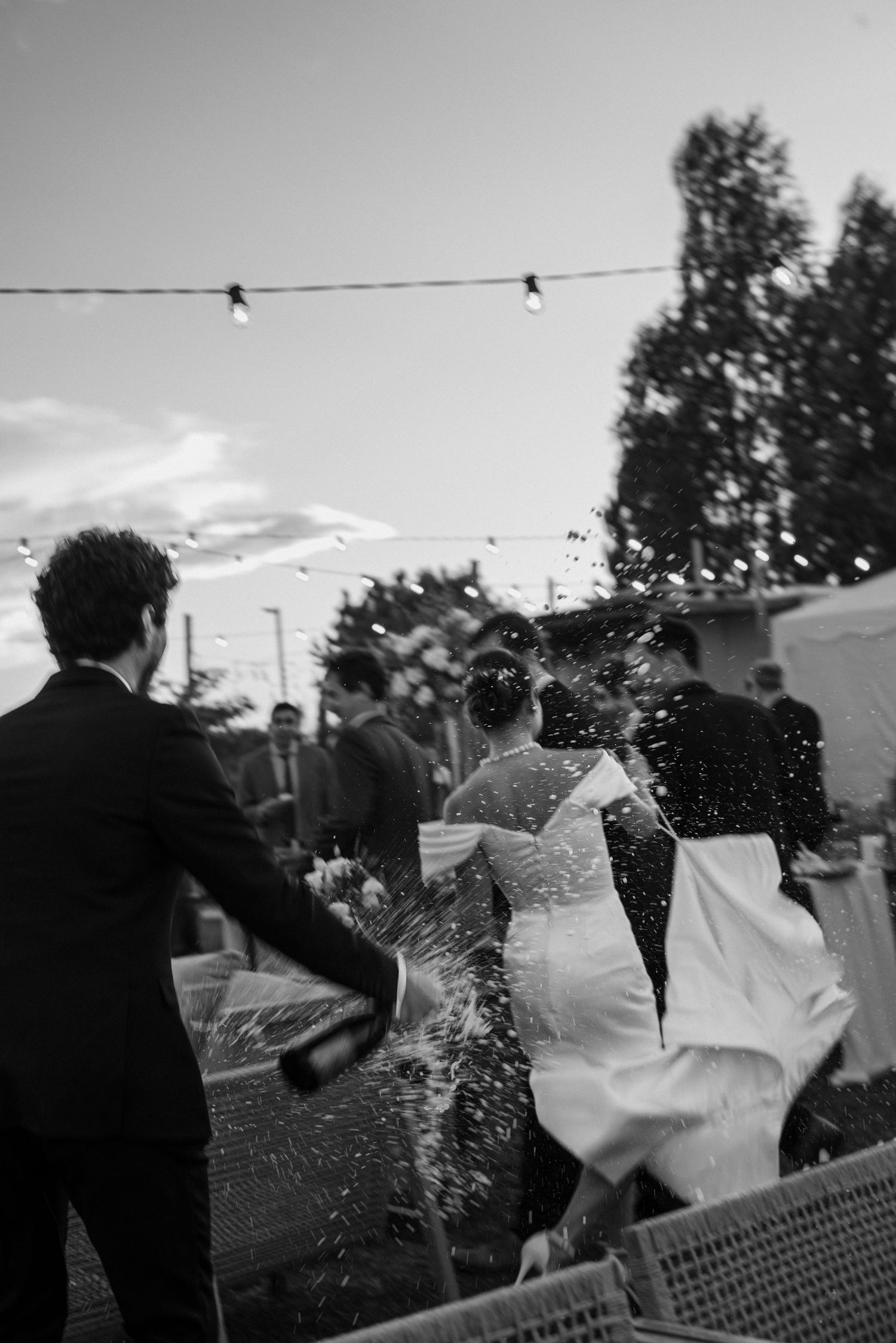 A sequence of black and white photos showing a couple dancing together in an outdoor setting at sunset.