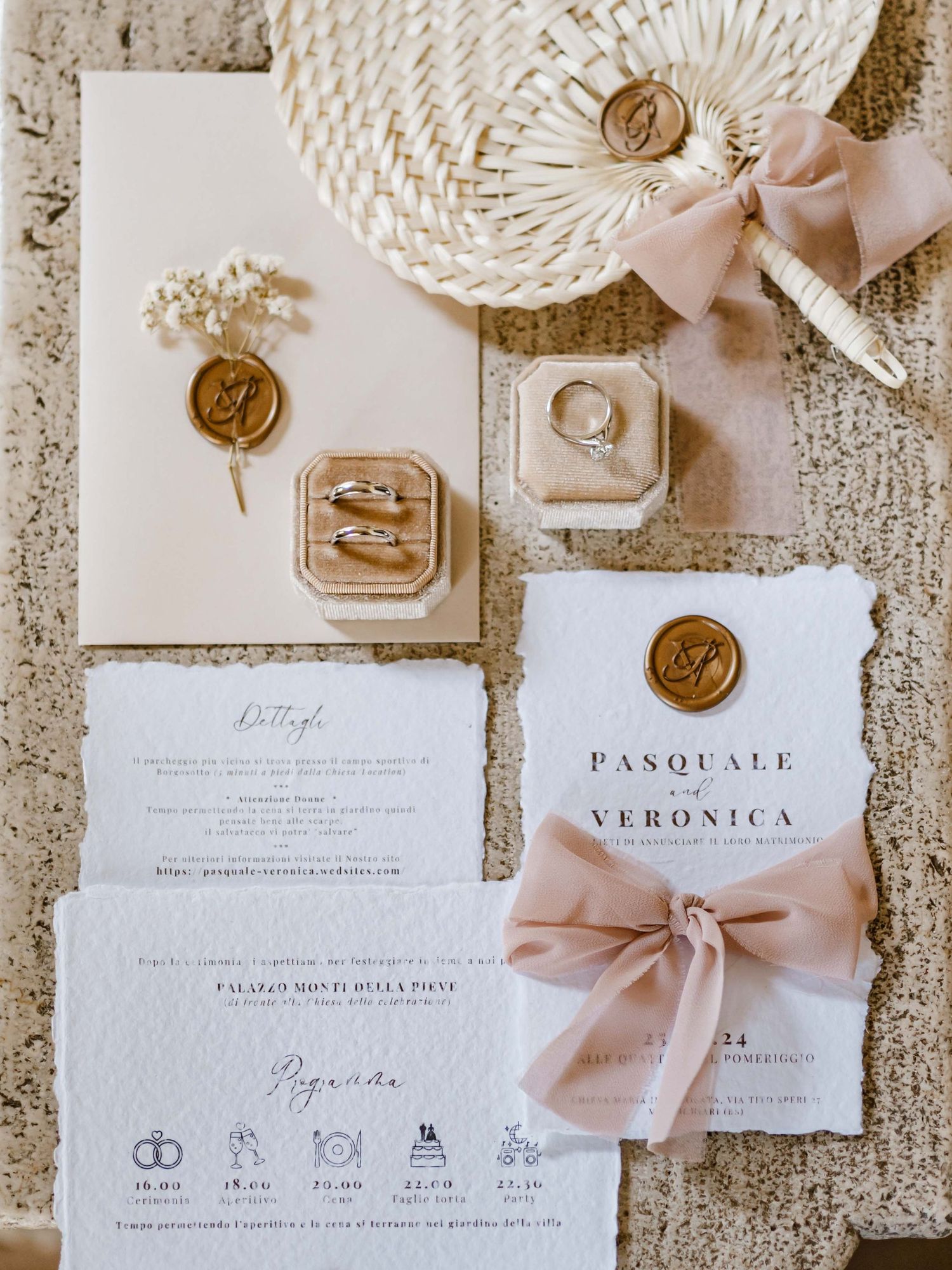 Wedding stationery suite with wax seals and pink ribbon in neutral tones.