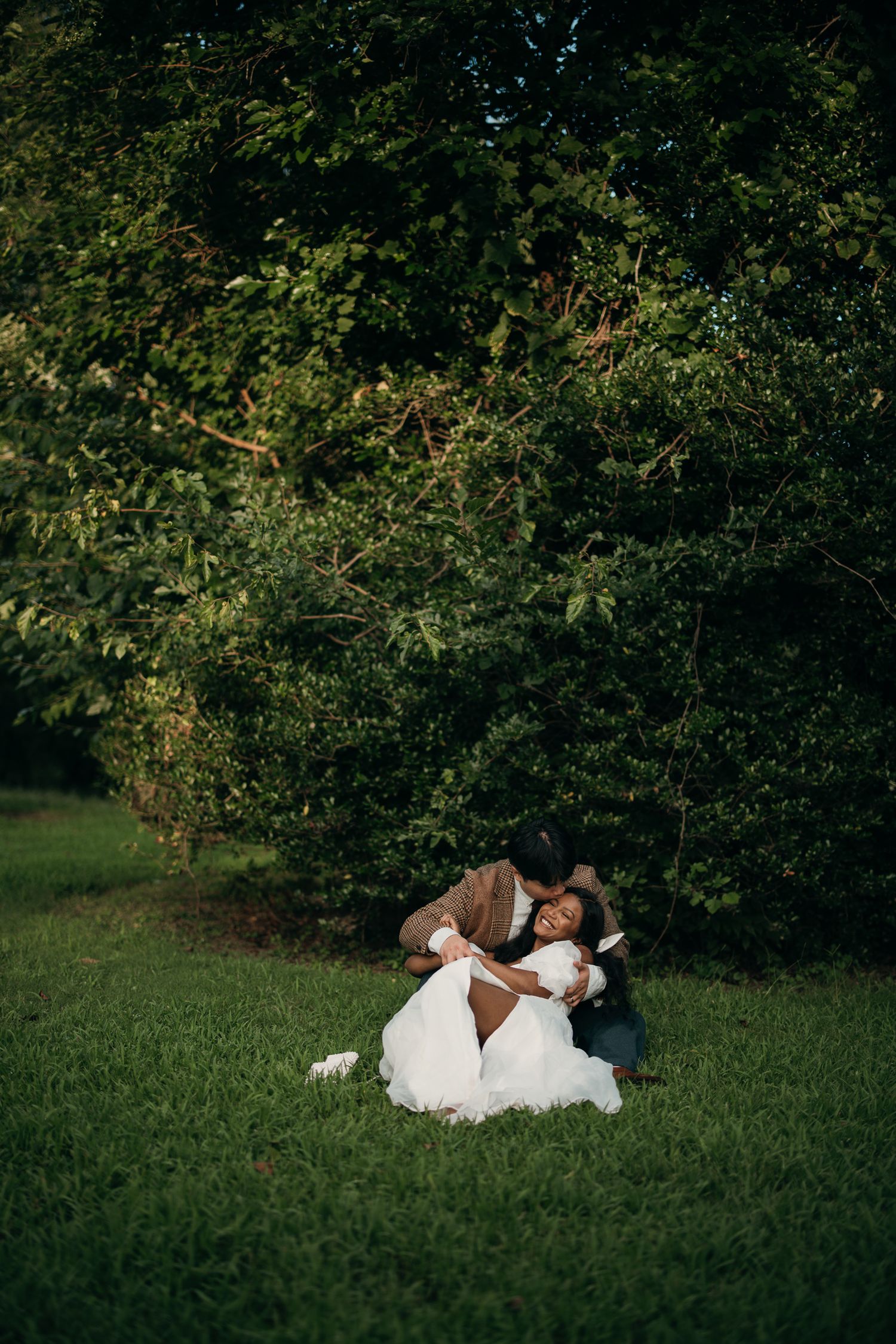 Candid elopement photography of a couple laying in the grass at Piedmont Park, Atlanta.