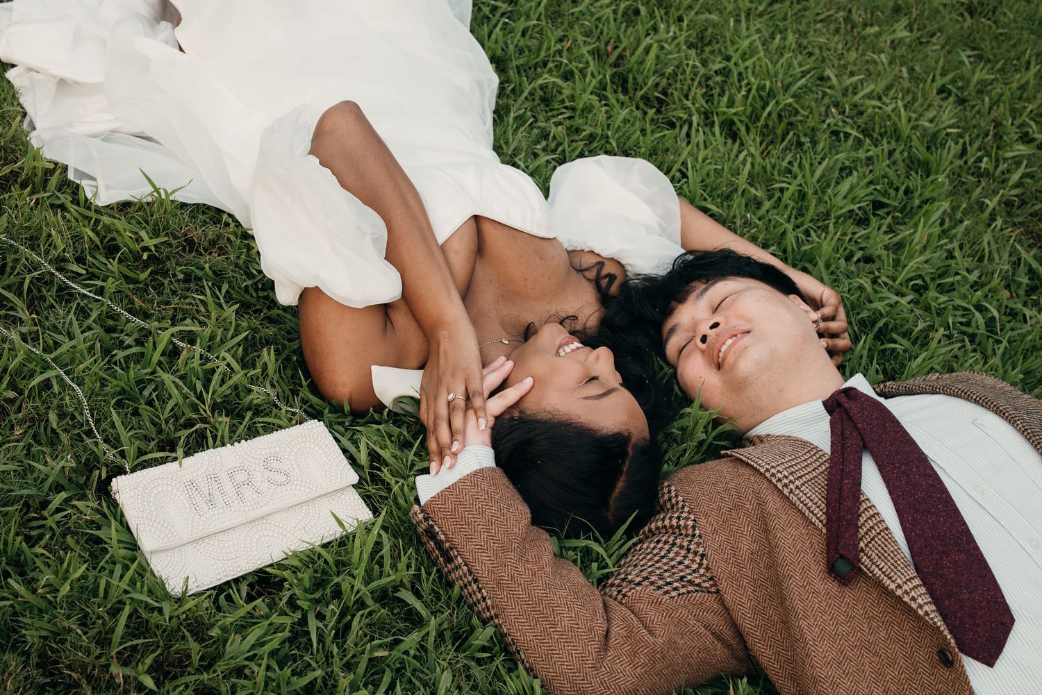 Candid elopement photography of a couple laying in the grass at Piedmont Park, Atlanta.