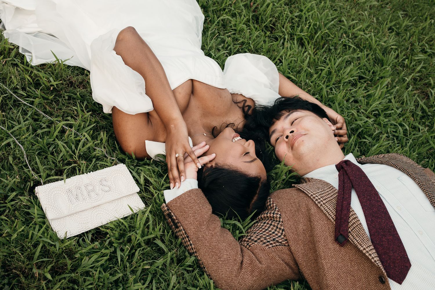 Candid elopement photography of a couple laying in the grass at Piedmont Park, Atlanta.