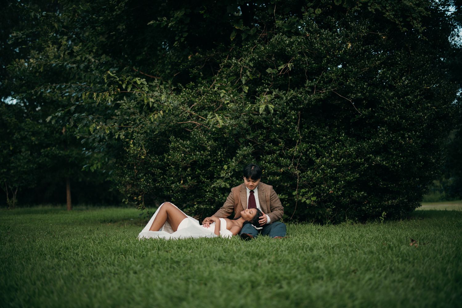 Candid elopement photography of a couple laying in the grass at Piedmont Park, Atlanta.