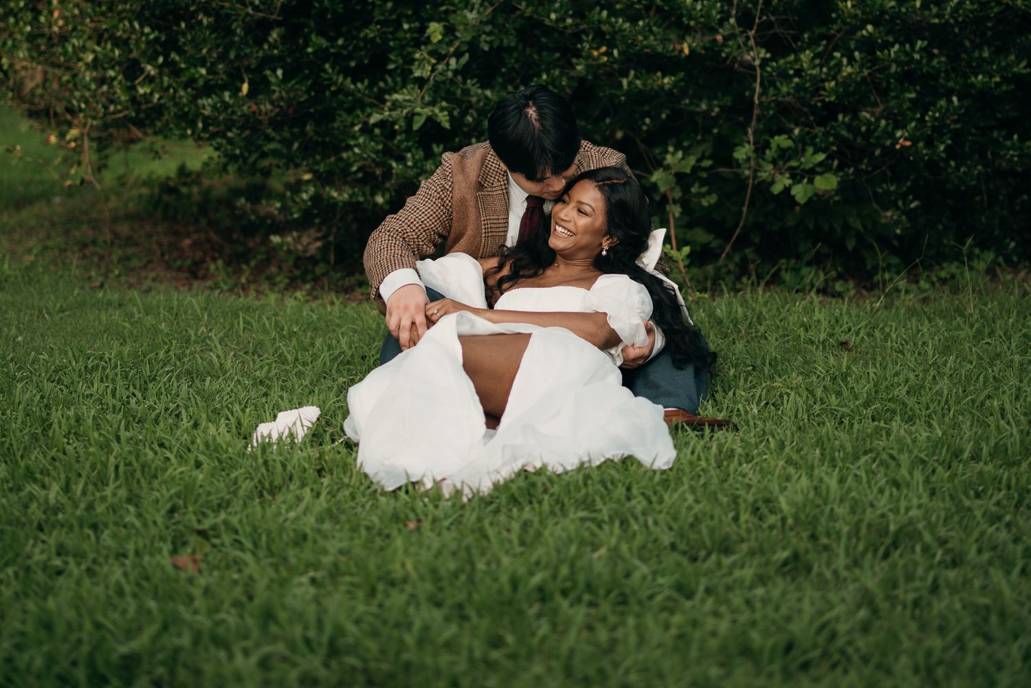 Candid elopement photography of a couple laying in the grass at Piedmont Park, Atlanta.