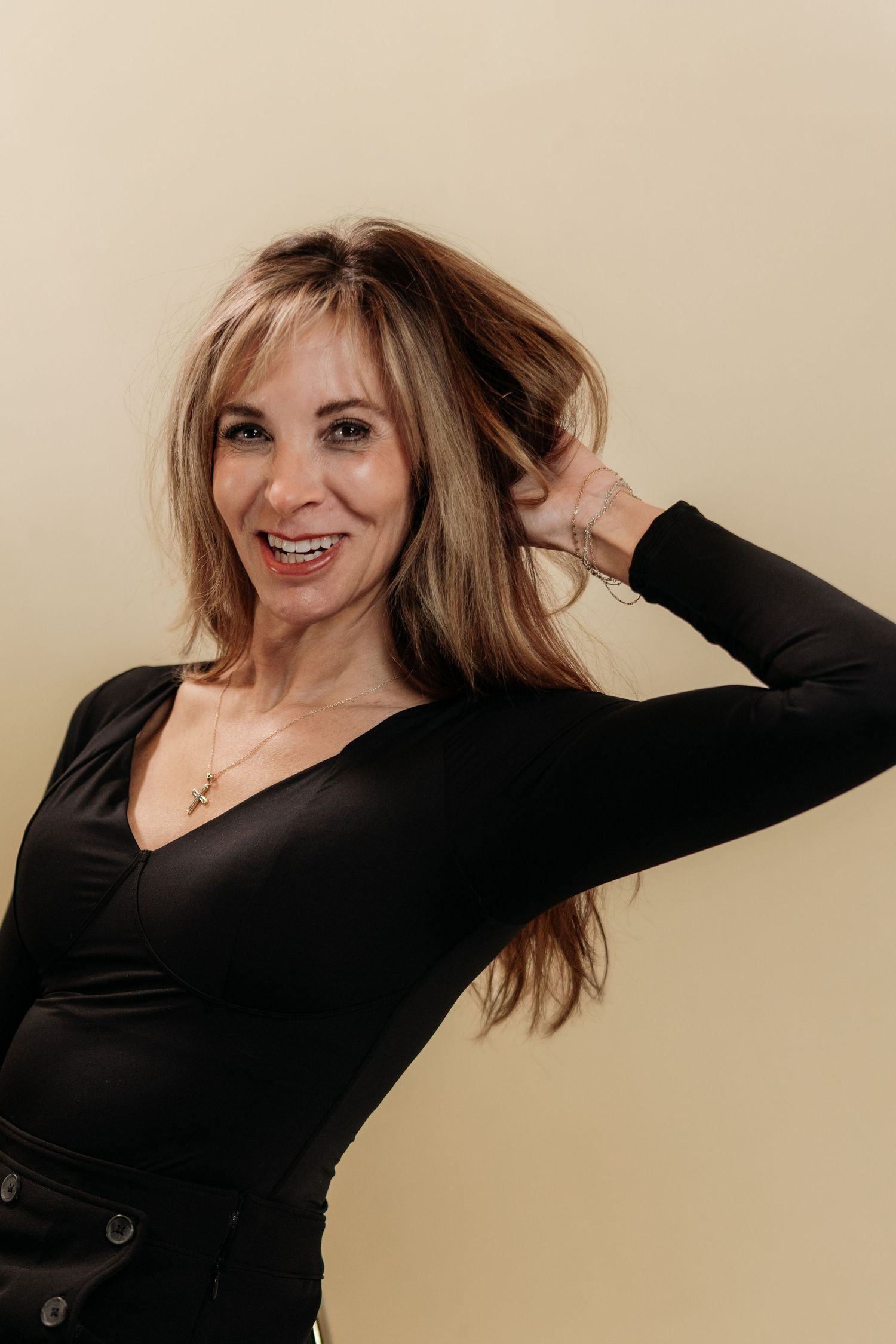A series of dynamic poses in a black sweater against a beige background creates an energetic fashion portrait sequence.