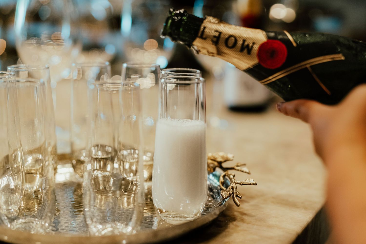 Row of clear drinking glasses arranged on wooden table at event. Session in Phoenix Arizona