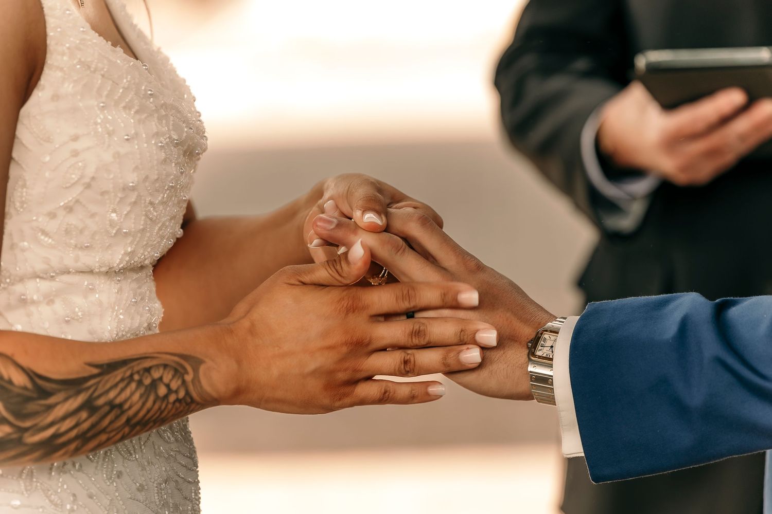 Close-up of hands exchanging wedding rings during a ceremony.