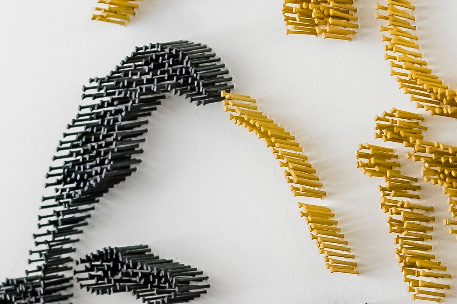 Abstract art piece created with gold and black pins arranged in curved patterns.