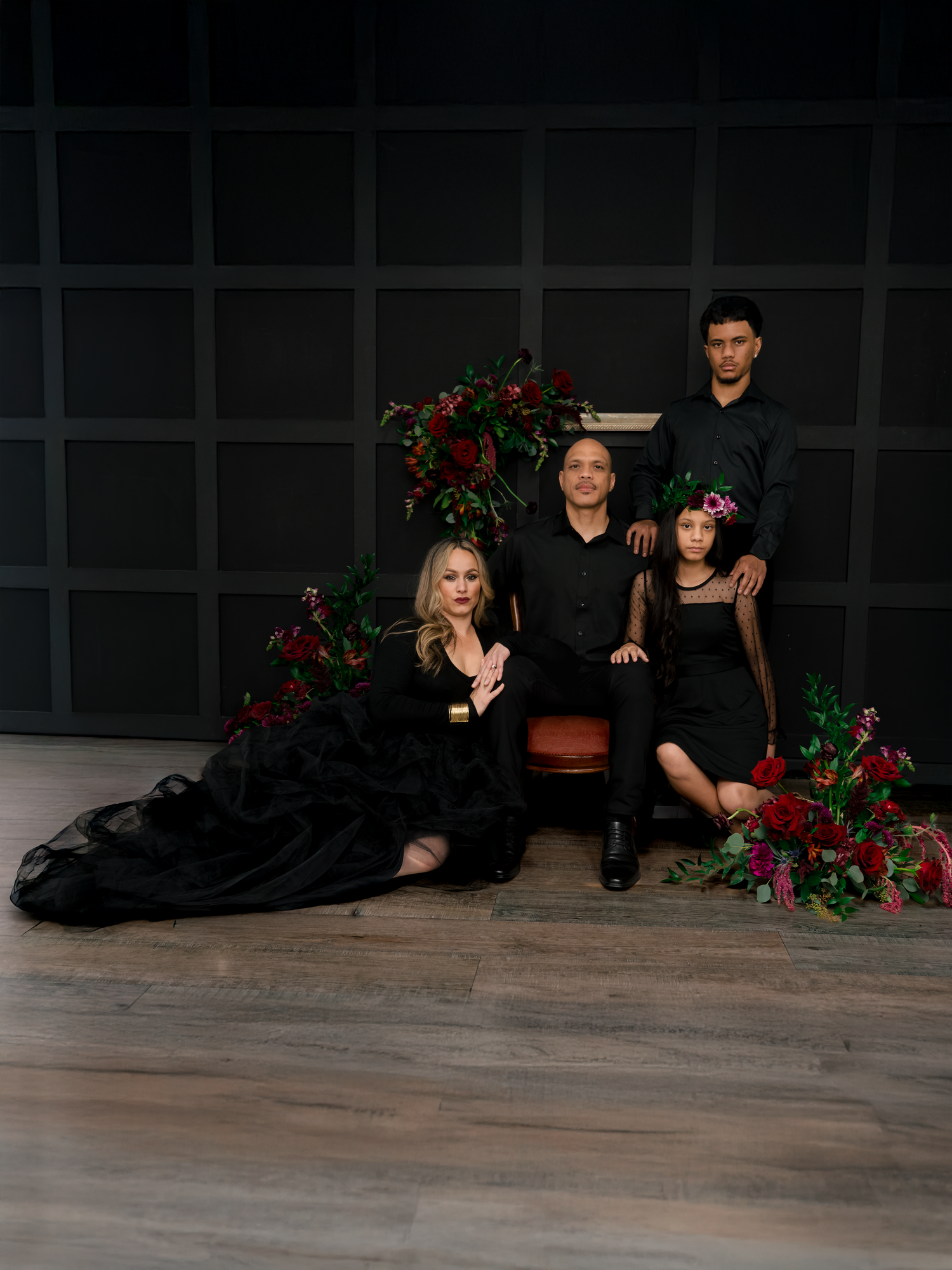 Four artistic dance poses captured in sequence showing performers on a dark floor with red floral decorations.