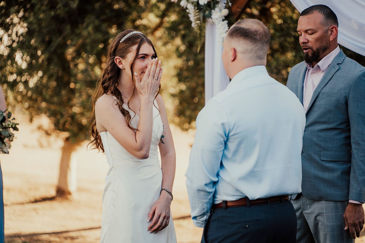 Emotional wedding party reactions during an outdoor ceremony.