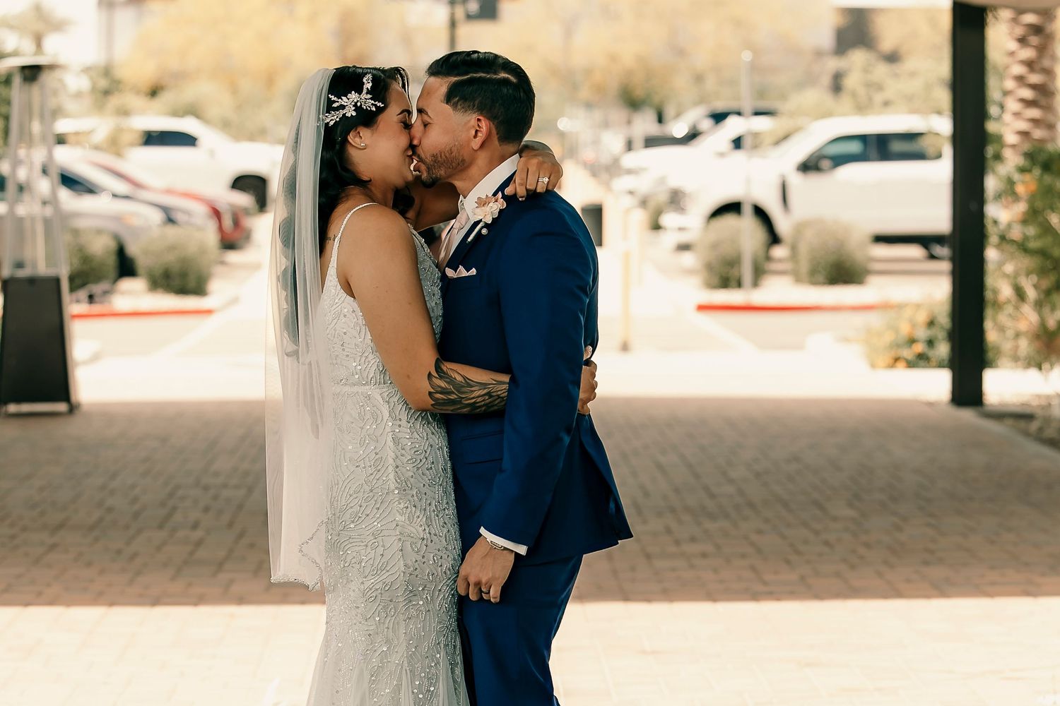 A romantic moment between newlyweds sharing their first kiss outdoors.