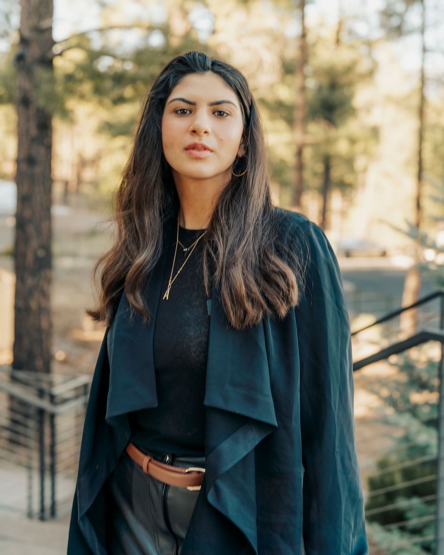 Series of outdoor fashion portraits featuring a model in an elegant black blazer against a natural backdrop.