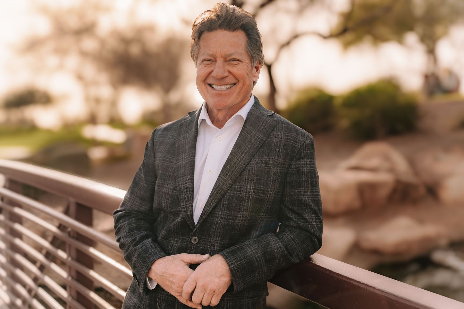 Business professional in plaid suit jacket smiling outdoors at sunset. Session in Anthem Arizona