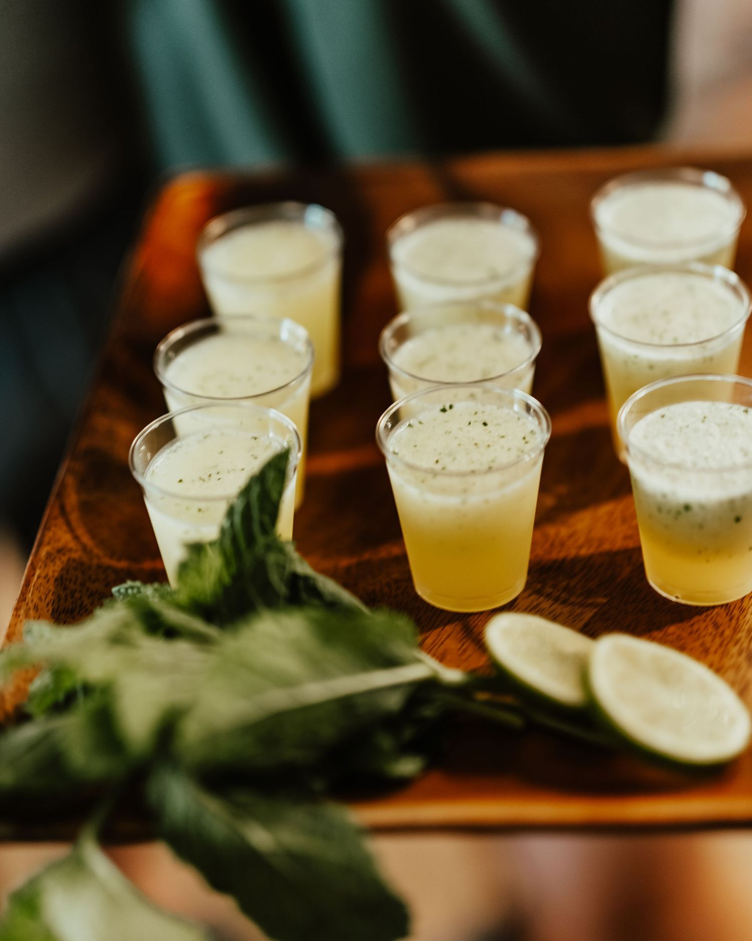 Line of yellow cocktails garnished with mint leaves on wooden serving board. Session in Phoenix Arizona