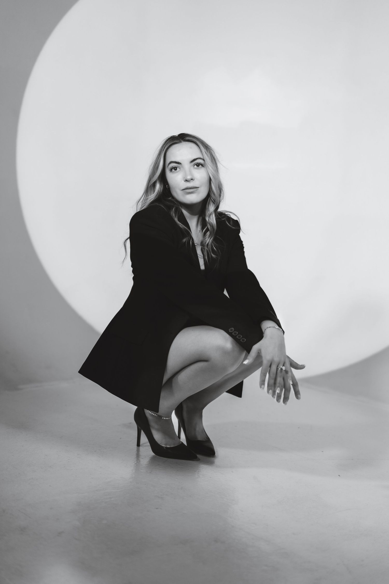 Black and white fashion photoshoot series showing dynamic poses against minimalist backdrop with dramatic lighting.