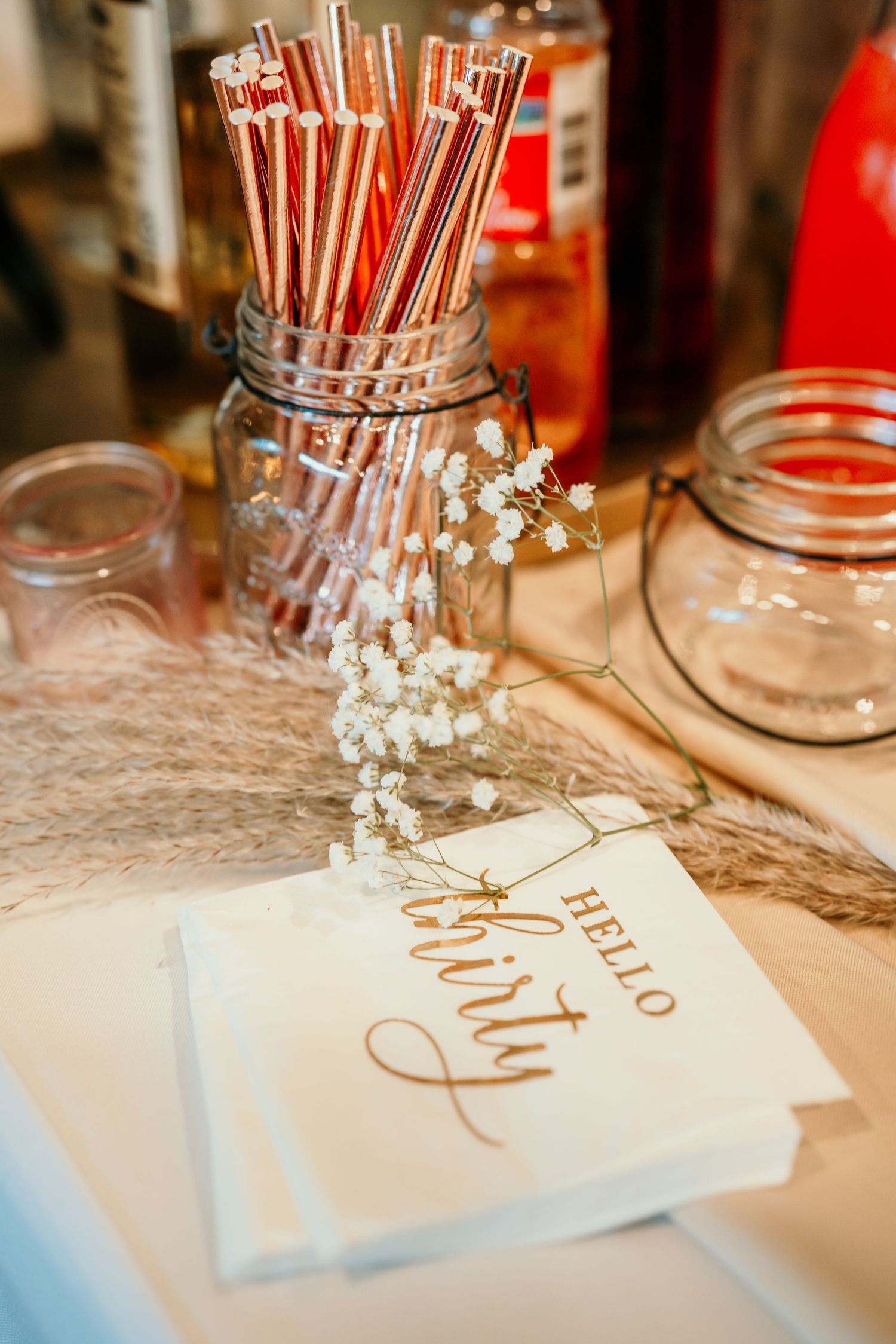 Vintage mason jars with striped straws and baby's breath flowers on rustic wedding table setting. Session in Anthem Arizona