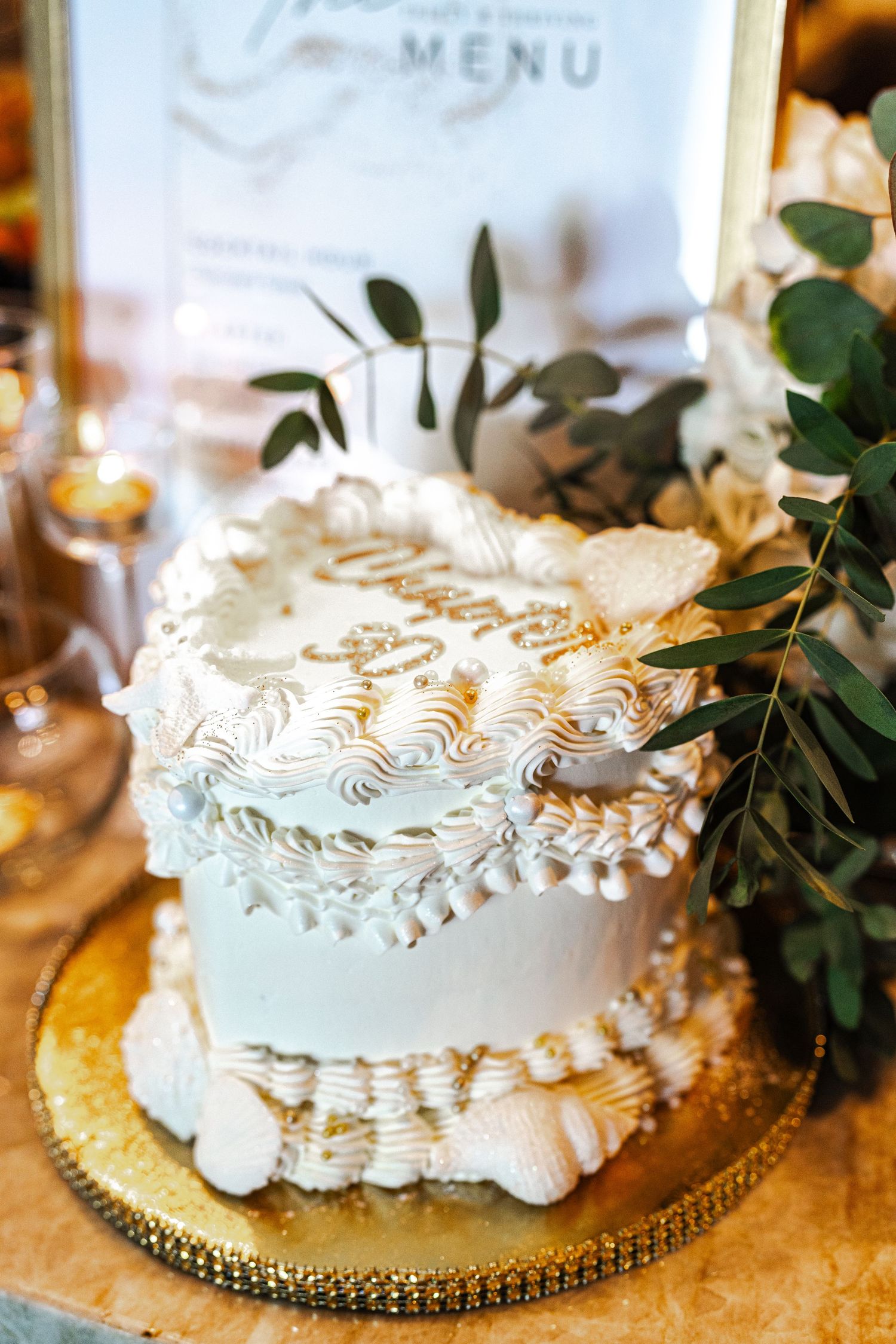 Elegant white wedding cake with meringue piping and eucalyptus decoration on gold stand. Session in Phoenix Arizona